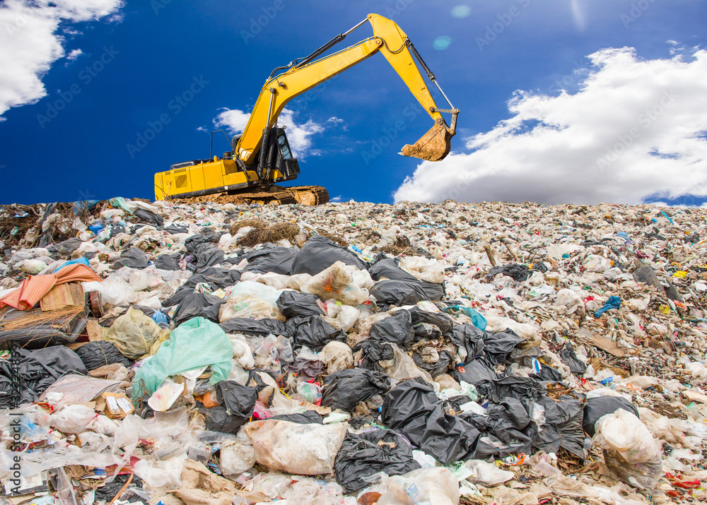 garbage dump pile in trash dump or landfill,backhoe is dumping the