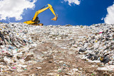 garbage dump pile in trash dump or landfill,backhoe is dumping the gabage from municipal,garbage dump whit old backhoe and blue sky