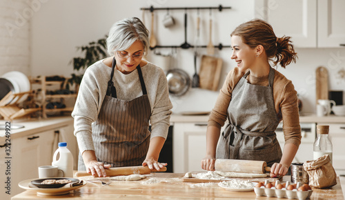 happy family grandmother  old mother mother-in-law and daughter-in-law daughter cook in kitchen, knead dough, bake cookies.