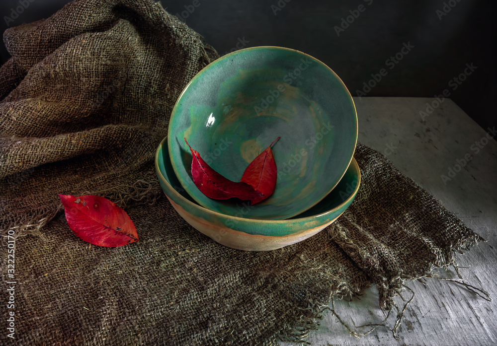 Still life with ceramic bowls and autumn leaves on burlap. Vintage. Minimalism.