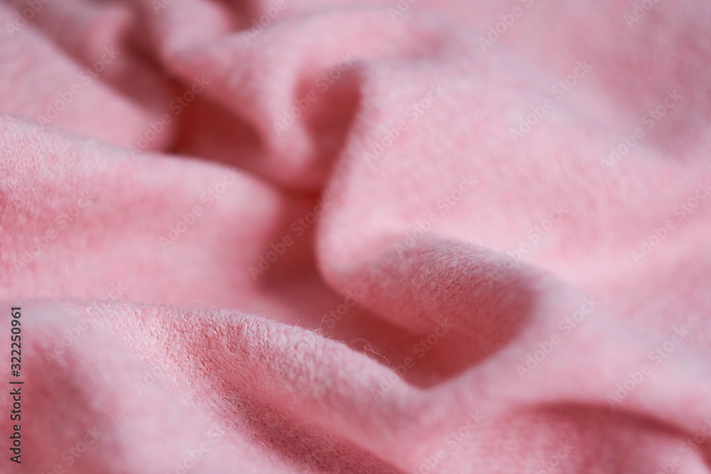 Fototapeta premium soft knitted fabric made of cashmere with large folds, a detail of clothes. pink fabric texture