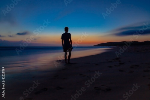 silhouette of a man running on the beach at sunset