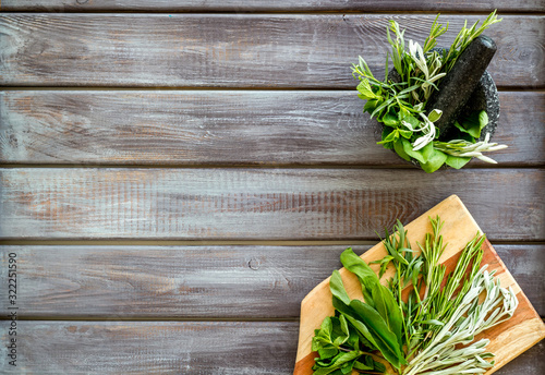 Make seasoning and condiments. Herbs in mortar on dark wooden background top-down copy space