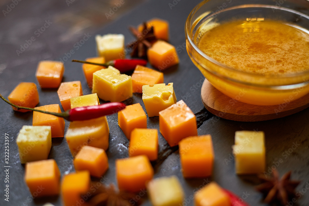 pieces of different cheese with honey on a stone plate pieces of different cheese with honey on a stone plate