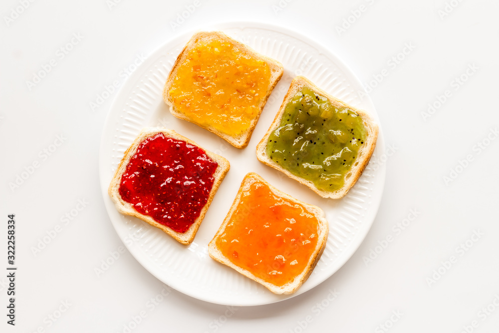 Toast with colorful fruit jam frame on white background Toast with colorful fruit jam frame on white background