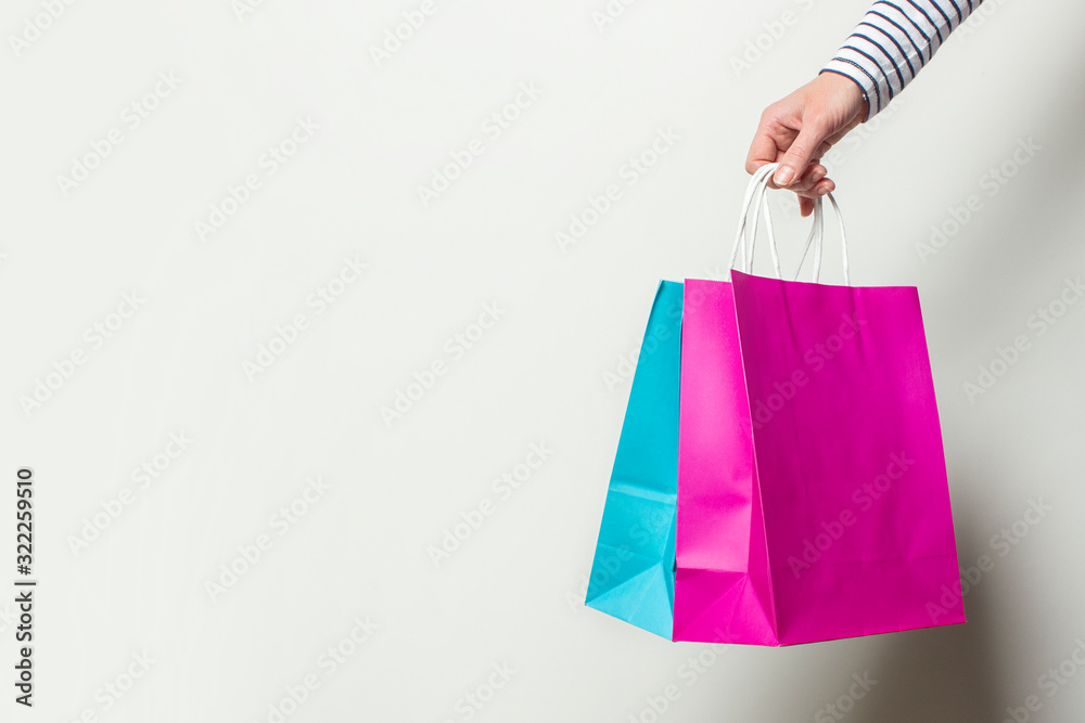 Female hand holds shopping bags on a white background. Concept shopping, discount, sale. Banner