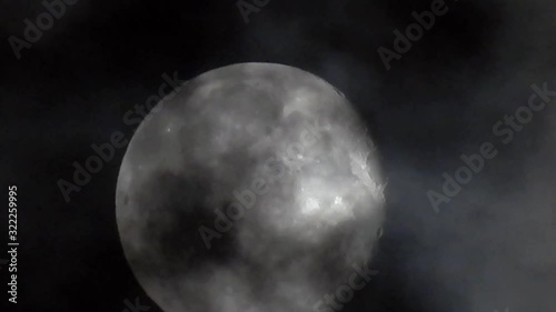 Glowing full moon dramatic night moody sky clouds passing detailed moon crater surface. Clip sixteen.