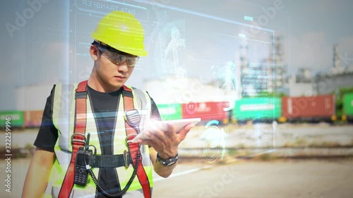 Male Industrial Engineer Works with glasses shows a conceptual hologram Industrial robot arm consisting on blurred background of large industry 