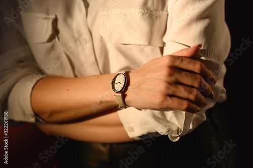 close up fashion details, young business woman wearing golden watch and white shirt. ideal fall outfit accessories.