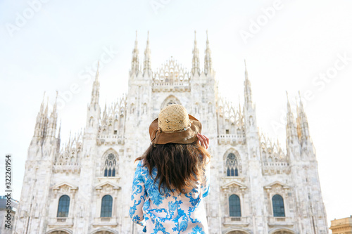 Travelver with a hat looking the front of Milan Duomo in Italy during the day