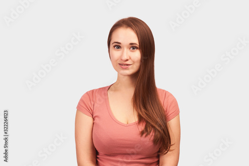 Young beautiful girl isolated on white background in Studio. Woman looks with calm expression, People, natural beauty and concept of youth