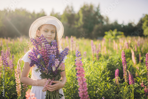 Lovely girl in a white dress in a field of flowers