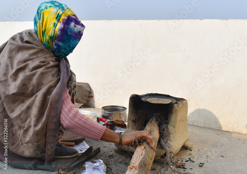 Woman cooking food on wood fire