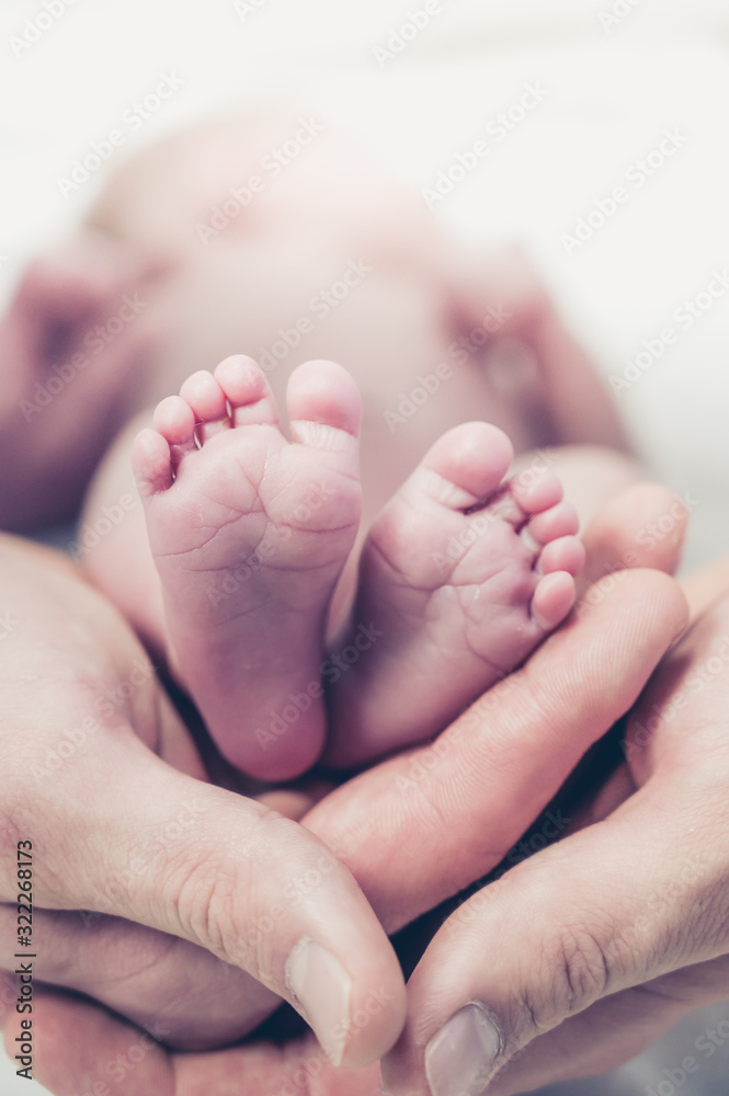 Feet of a newborn baby in the hands of parents. Happy family moment and concept. Feet of a newborn baby in the hands of parents. Happy family moment and concept.