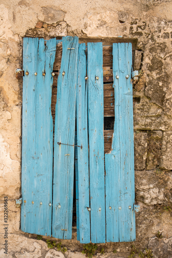 Old cracked blue wooden window in a stone house. Les Baux-de-Provence, Provence, France