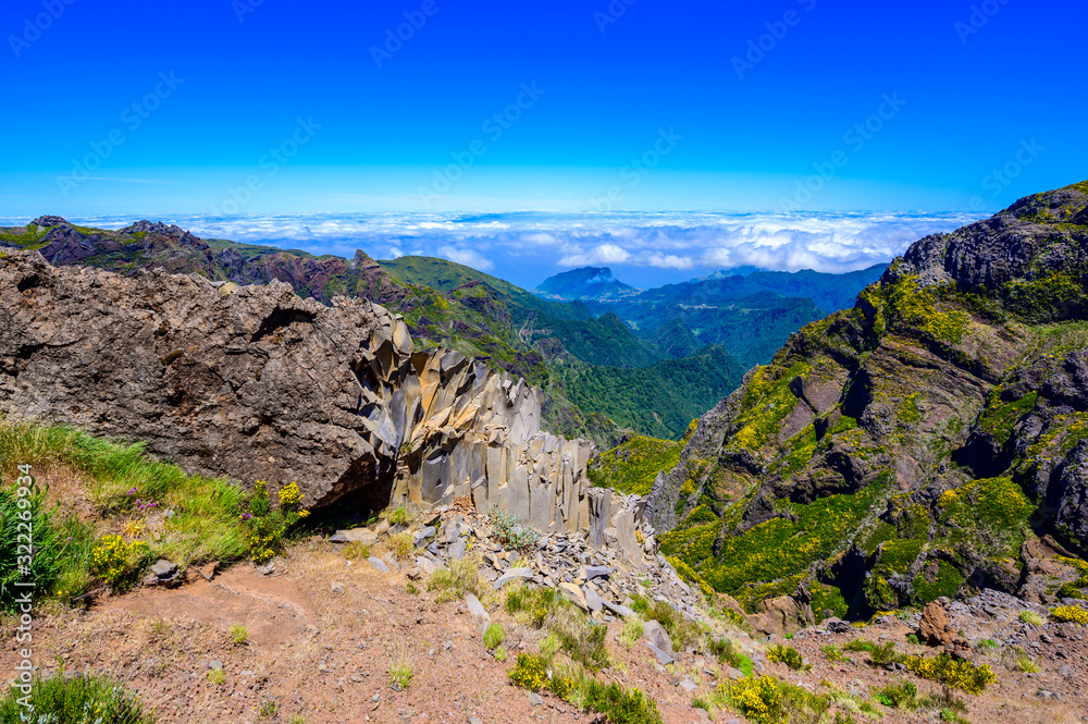 Beautiful hiking trail from Pico do Arieiro to Pico Ruivo, Madeira island. Footpath PR1 - Vereda do Areeiro. On summy summer day above the clouds. Portugal.