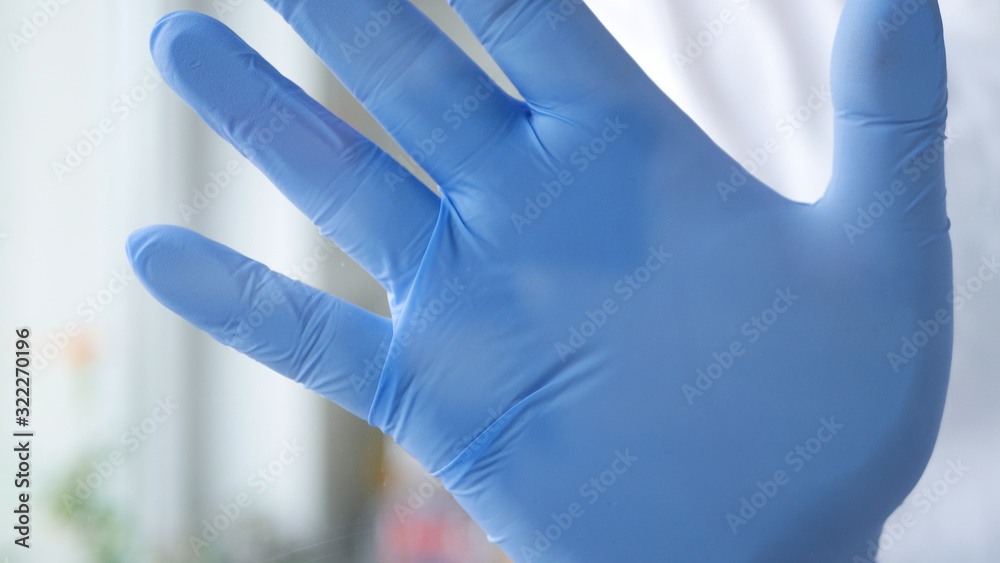 Doctor in a Hospital Room Put His Hand with Glove on the Window Making a Stop Hand Gestures Doctor in a Hospital Room Put His Hand with Glove on the Window Making a Stop Hand Gestures