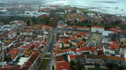 Aerial, tilt, drone shot, overlooking traffic on the streets of Aveiro city, on a cloudy evening, in Centro, Portugal