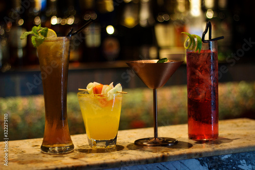 Different colored cocktails at a bar counter