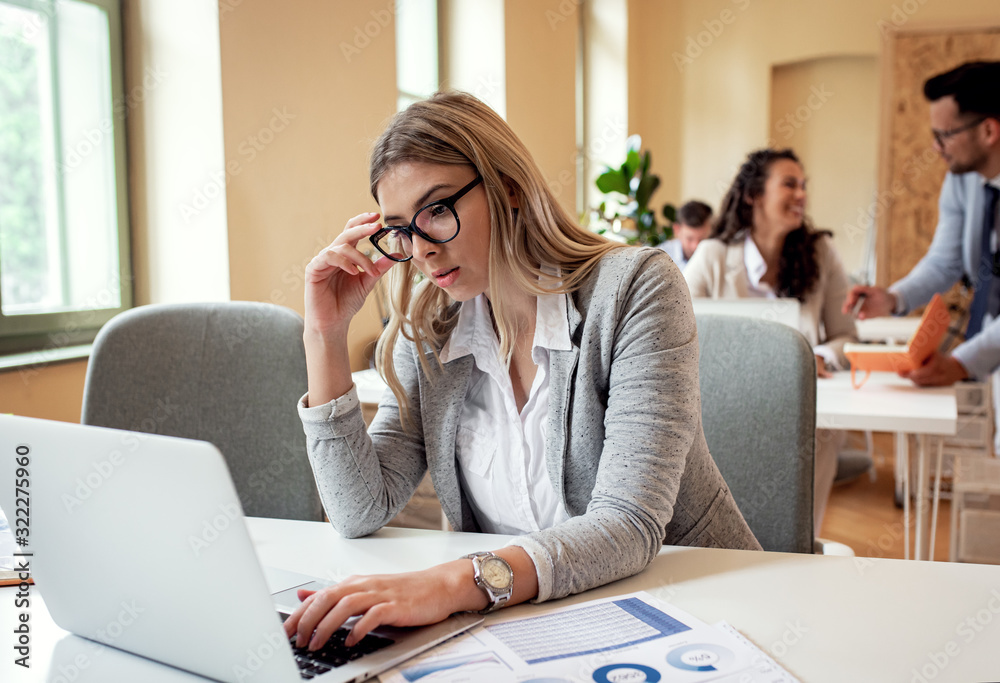 Portrait of young businesswoman working on a laptop at the office unable to solve the problem. Portrait of young businesswoman working on a laptop at the office unable to solve the problem.