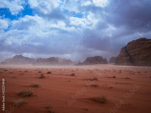 Beautiful Scenery Scenic Panoramic View Red Sand Desert and Ancient Sandstone Mountains Landscape in Wadi Rum, Jordan during a Sandstorm © thecriss