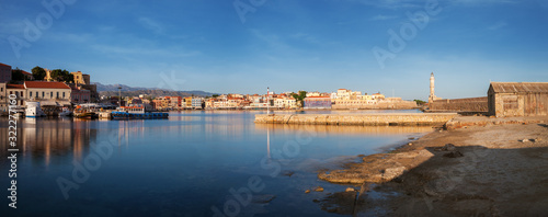 Panoramic view of Old harbor of Chania with the lighthouse and fortification at sunrise, Crete, Greece