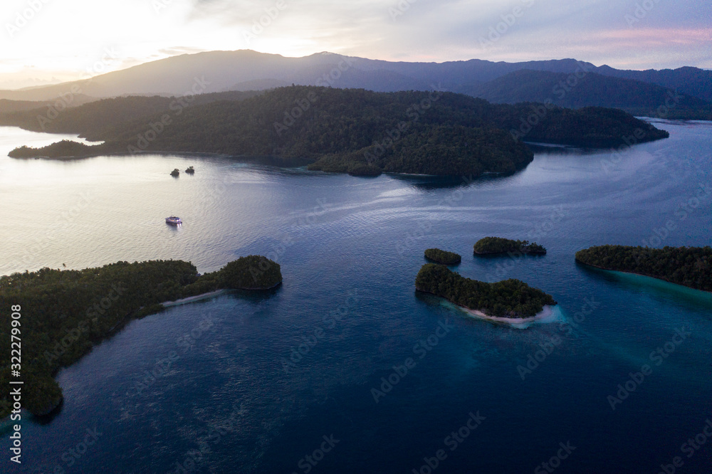 A serene sunrise illuminates the dramatic tropical islands within Raja Ampat, Indonesia. This beautiful region is thought to be the world's epicenter of marine biodiversity.