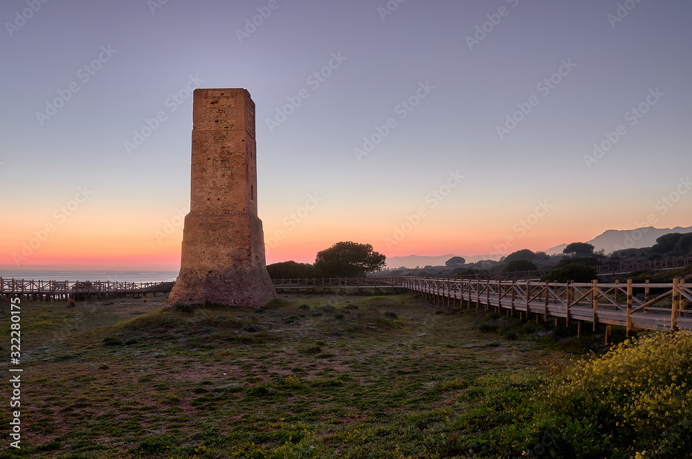 Torre de los ladrones Tower of the Thieves on sunset in Dunas de Artola natural monument, Cabopino, Andalusia, Costa del Sol