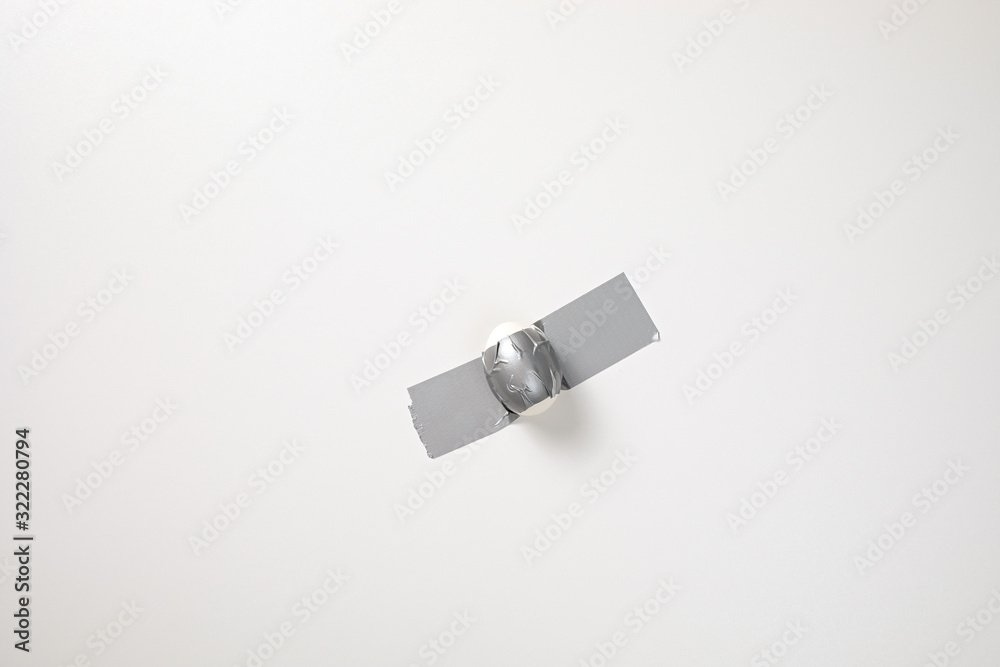 An Egg Duct-Taped to a Wall, like a famous art object, a banana. Easter Egg Creative Concept. Conceptual Photo An Egg Duct-Taped to a Wall, like a famous art object, a banana. Easter Egg Creative Concept. Conceptual Photo