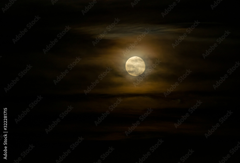 full moon behind clouds