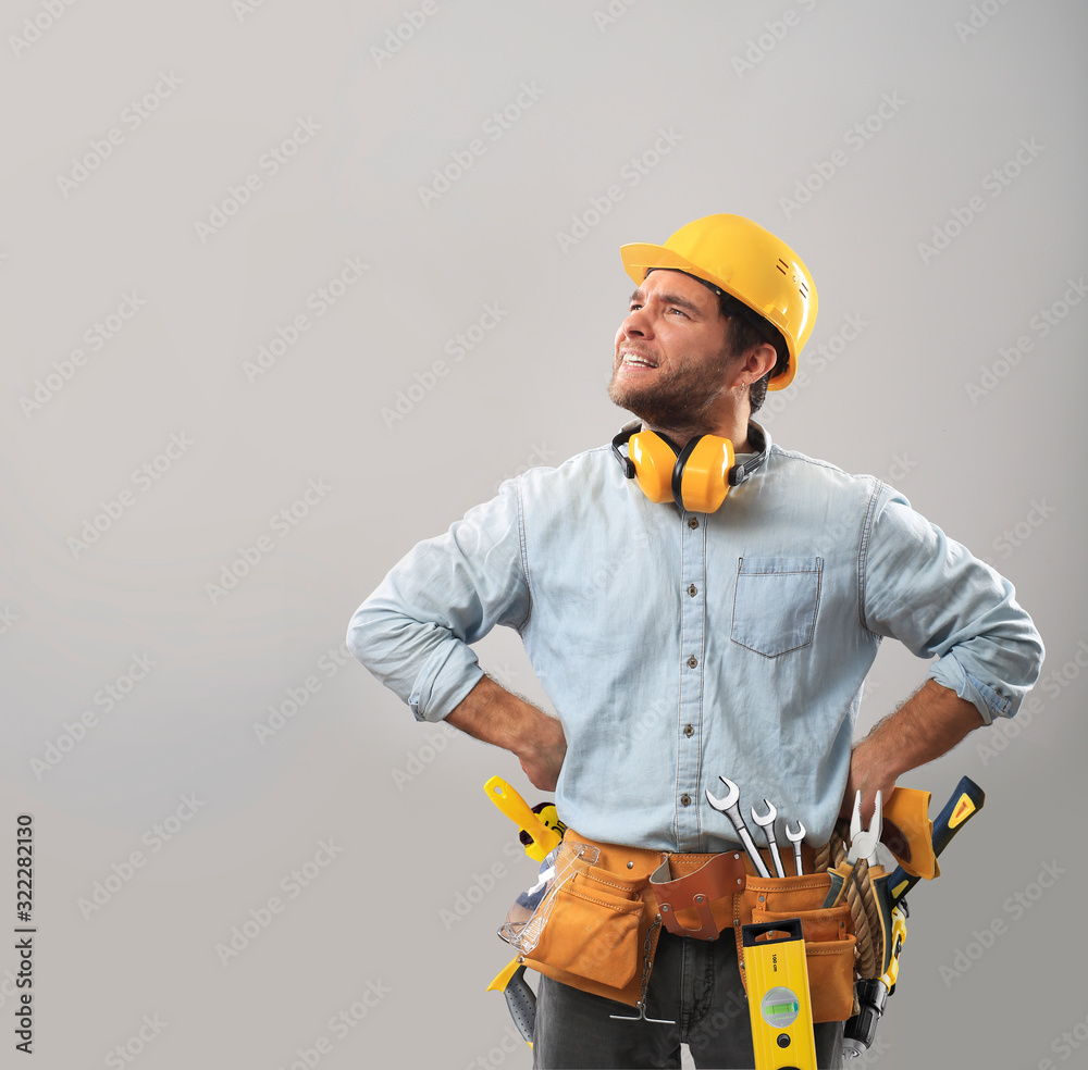 Builder in a yellow helmet with tools Builder in a yellow helmet with tools