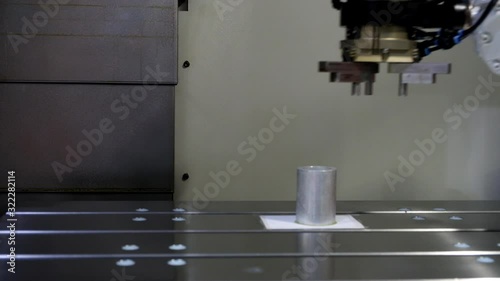 Close-up Industrial robotic using grip arm catch silver metal workpiece and put gold metal workpiece to replace on CNC machine on smart factory, Industry 4.0 technology and copy space