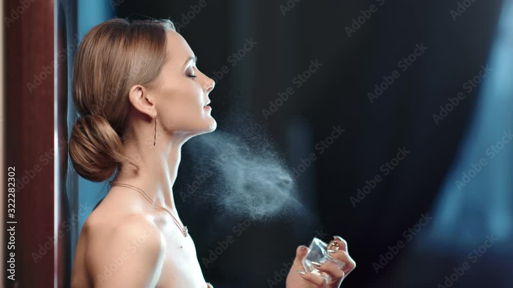 Adorable naked woman spraying perfume on neck slow motion. Medium close up shot on 4k RED camera