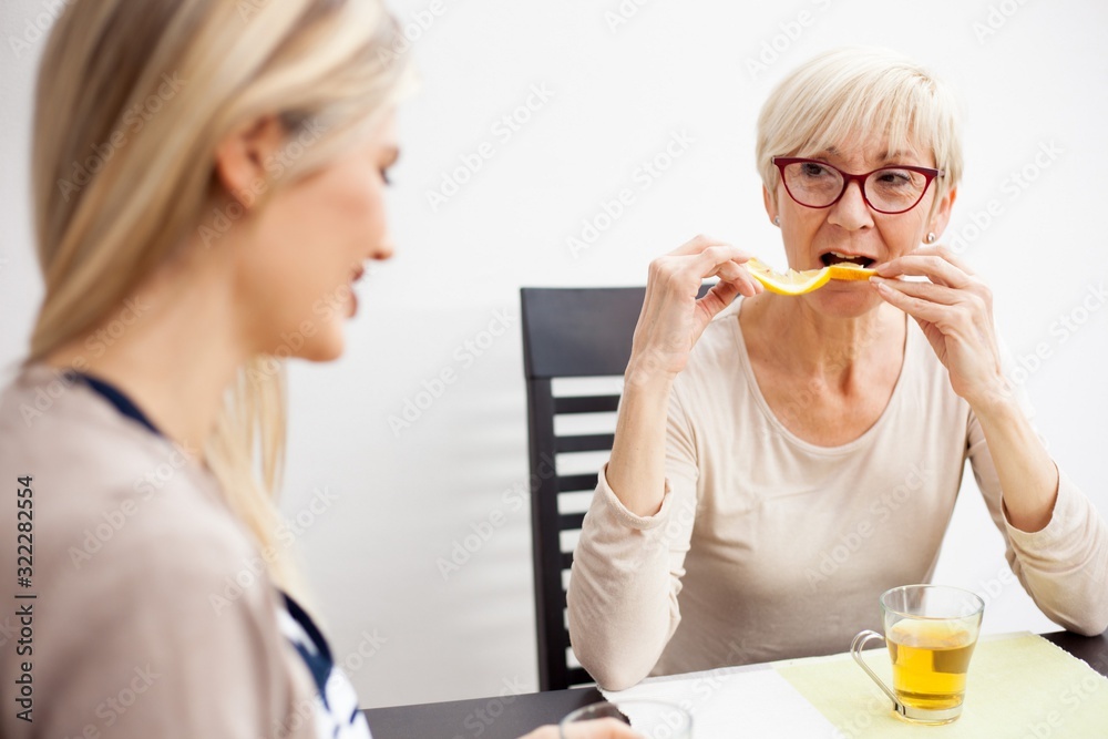 Senior mother and daughter talking and drinking tea in brightly Senior mother and daughter talking and drinking tea in brightly