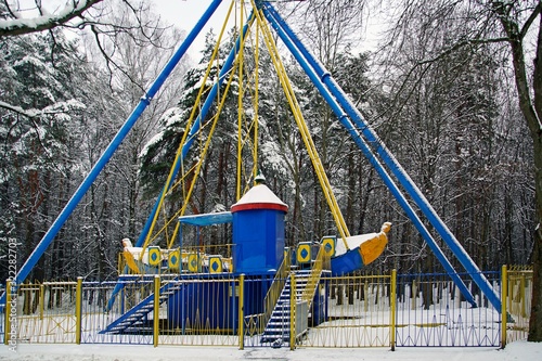 Children's amusement park is closed. Not a season. Winter and snow. Swings do not work