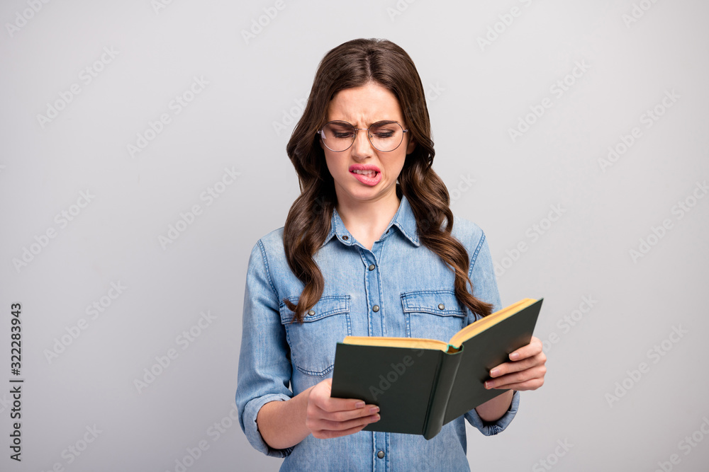 Ugh. Photo of pretty business lady hold book hands reader bad mood read disgusting chapter grinning wear specs casual jeans denim shirt isolated grey color background Ugh. Photo of pretty business lady hold book hands reader bad mood read disgusting chapter grinning wear specs casual jeans denim shirt isolated grey color background