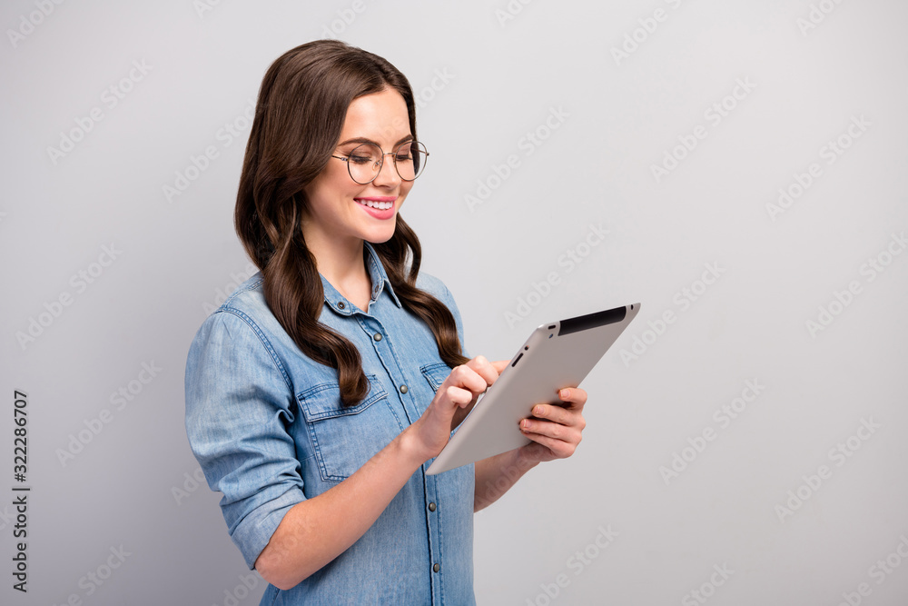 Profile photo of beautiful freelancer lady hold e-reader tablet searching information reading working report wear specs casual jeans denim shirt isolated grey color background Profile photo of beautiful freelancer lady hold e-reader tablet searching information reading working report wear specs casual jeans denim shirt isolated grey color background