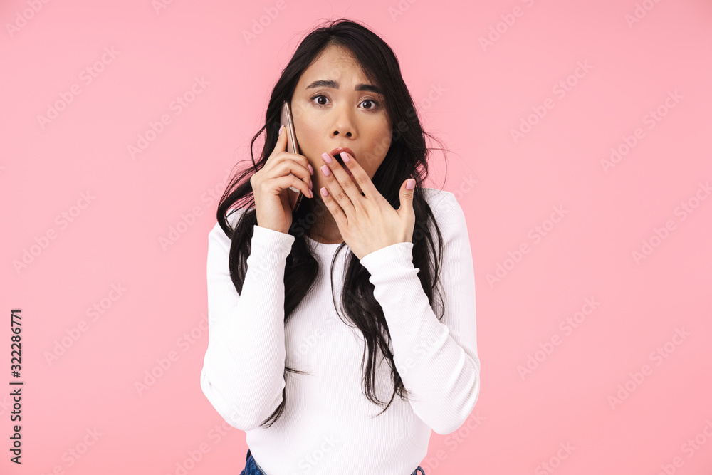 Image of young brunette asian woman with long hair talking on cellphone Image of young brunette asian woman with long hair talking on cellphone