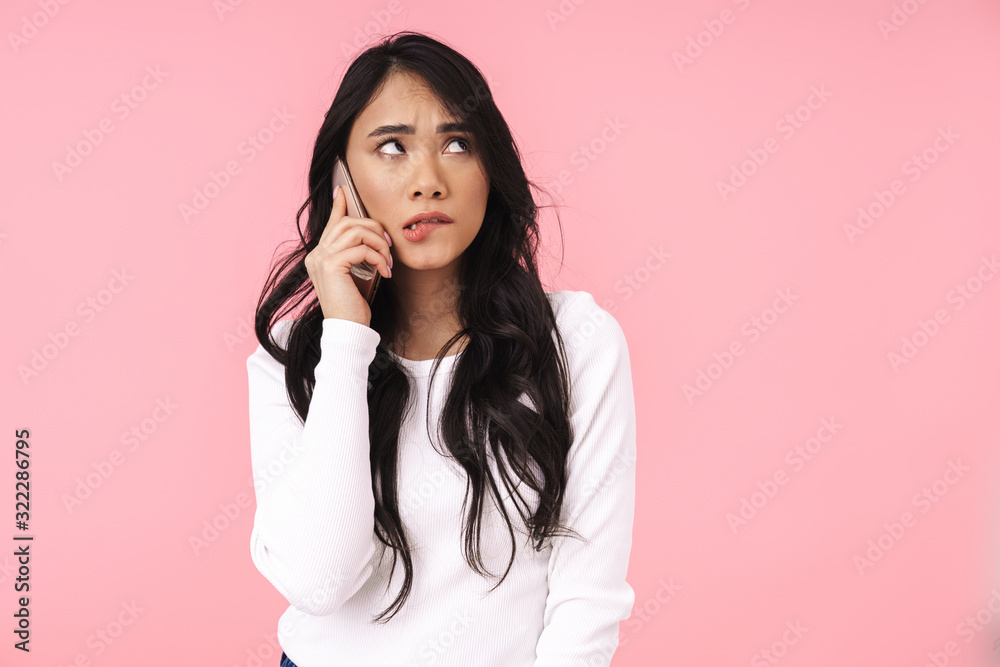 Image of young brunette asian woman with long hair talking on cellphone Image of young brunette asian woman with long hair talking on cellphone