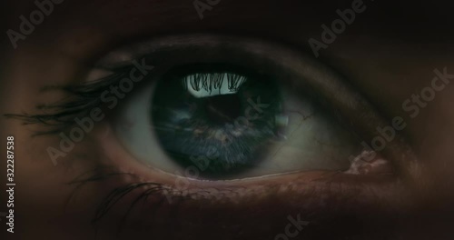 Female Racer in helmet. Macro shot of the eye with road reflections.