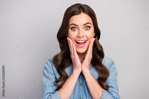 Closeup photo of beautiful pretty curly lady positive good mood open mouth listen unexpected positive news arms on cheeks wear casual jeans outfit isolated grey color background