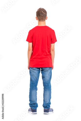 Full length portrait of young caucasian teen boy - rear view, isolated on white background. Funny teenager - back view. Handsome child wearing red t-shirt.