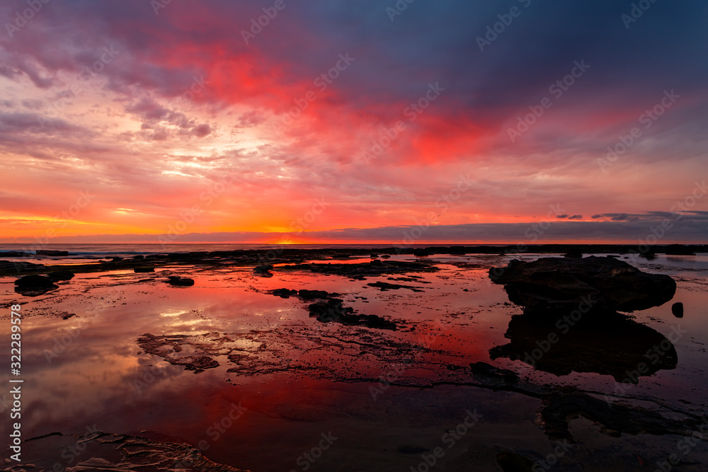 Sunrise seascape at low tide with vivid reflections