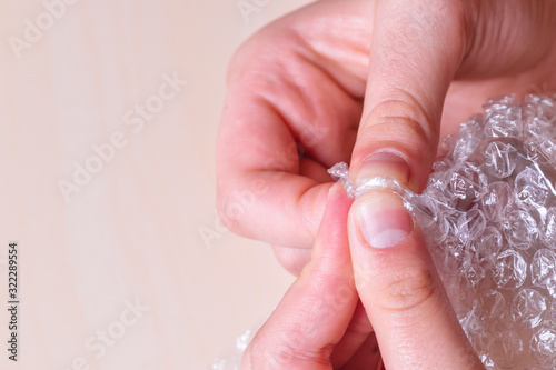 Stress concept. Woman's hands popping bubbles from a bubble paper.