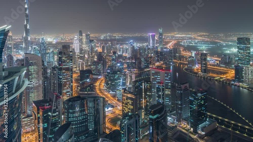 Wallpaper Mural Panoramic aerial view of business bay towers and downtown in Dubai night timelapse. Rooftop view of some illuminated skyscrapers, canal and new towers under construction. Torontodigital.ca