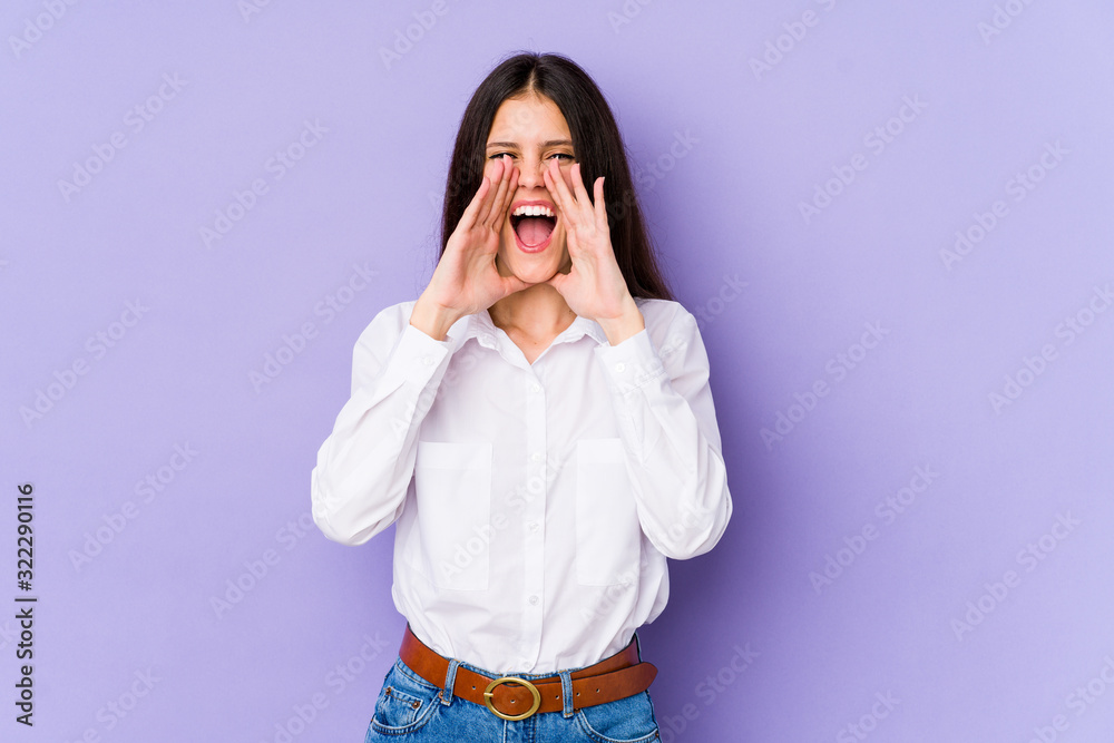 Young caucasian woman isolated on purple background shouting excited to front. Young caucasian woman isolated on purple background shouting excited to front.