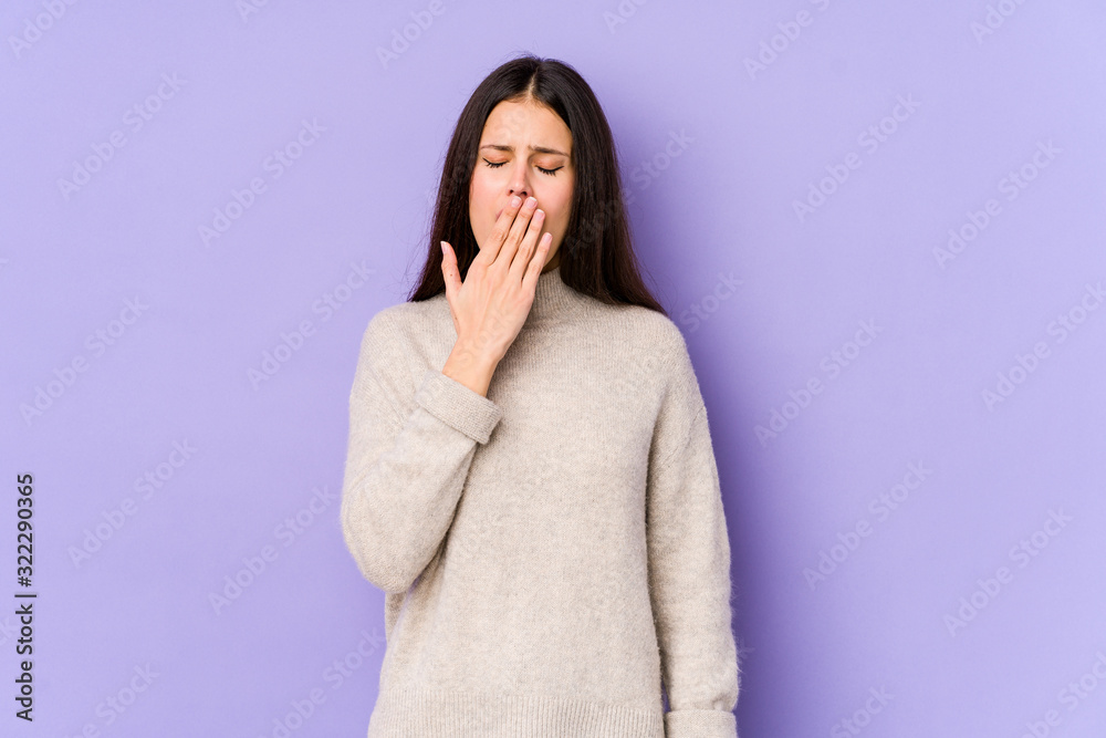 Young caucasian woman isolated on purple background yawning showing a tired gesture covering mouth with hand. Young caucasian woman isolated on purple background yawning showing a tired gesture covering mouth with hand.