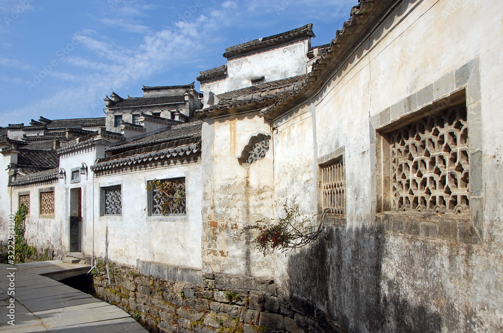 Xidi Ancient Town in Anhui Province, China. A quiet street in the old town of Xidi called the Back Rivulet. This path follows a small stream past local houses. Traditional architecture in Xidi, China.