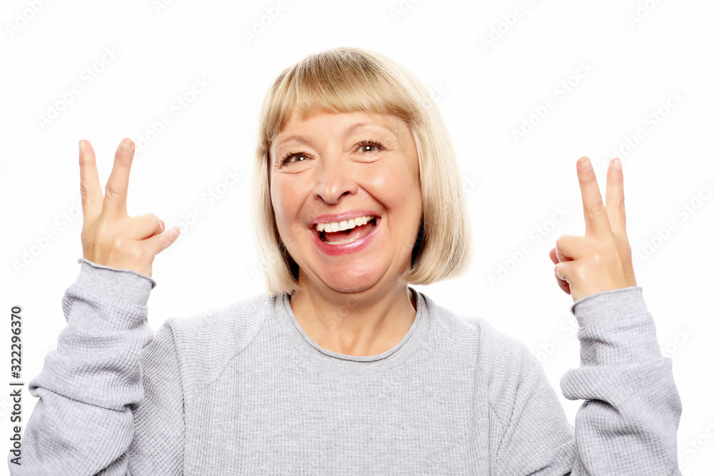 idea, attention and people concept - portrait of smiling senior woman pointing finger up over white background