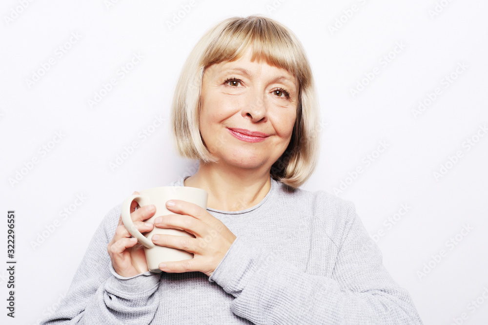 old excited lady smiling laughing, holding cup drinking coffee, tea, beverage on white background old excited lady smiling laughing, holding cup drinking coffee, tea, beverage on white background